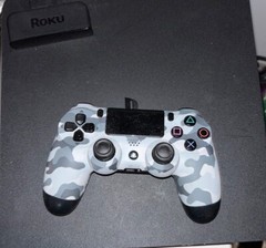 black ps4 console with a grey and black controller. + a black charging port.